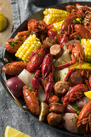 A southern crawfish boil with potatoes, sausage, corn, and other fixins in a large pot.