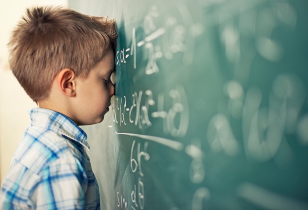 Little boy in math class overwhelmed by the math formula.