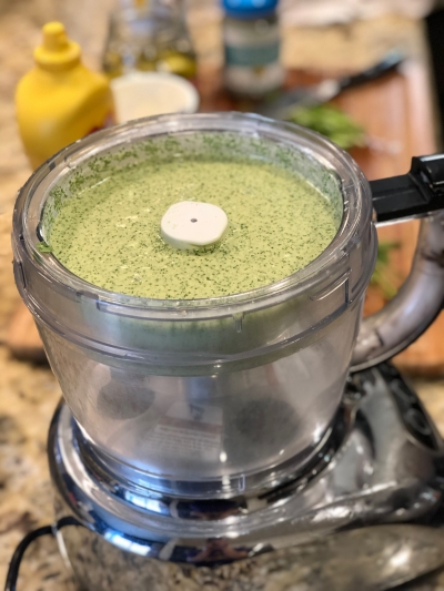 A food blender full of a green sauce.