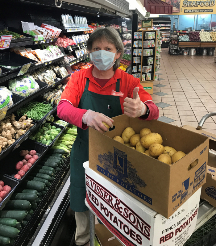 Man in produce in a face mask.